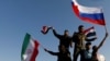 SYRIA -- Syrians wave Iranian, Russian and Syrian flags during a protest against U.S.-led air strikes in Damascus, April 14, 2018