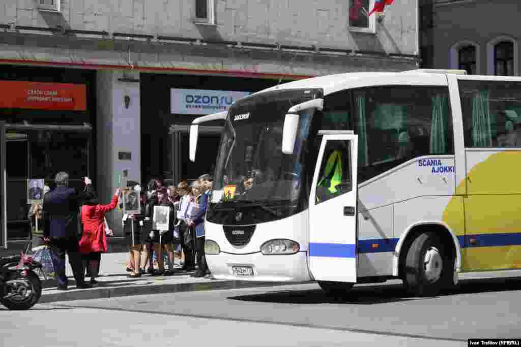 Тем временем уже собираются участники шествия "Бессмертного полка". Некоторых подвозят организованно