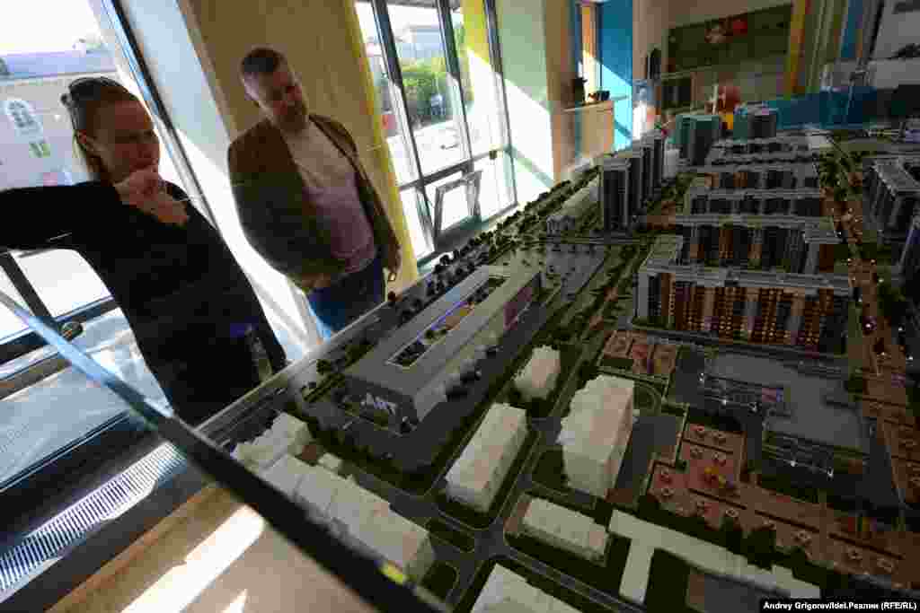 Макет с другого ракурса. Ближе к центру мы опять видим маленький белый макет — то самое снесённое здание. А вот на местах двух уцелевших пока корпусов уже в 2017-м располагались скромный скверик и огромная парковка. Все большие деревья, как мы видим, тоже подлежат уничтожению. 