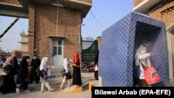 Staff members check temperatures of students as they arrive for an exam at a university in Peshawar, the capital of northwestern Khyber Pakhtunkhwa Province.