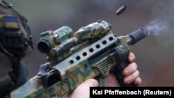 Pripadnik ukrajinskih specijalnih snaga testira oružje prije misije u regiji Bahmut 6. aprila.