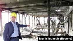 Miodrag Kostic, predsednik MK Group, na ovoj fotografiji iz maja 2002. pokazuje novinarima ostatke jednog od objekata uništenih tokom NATO bombardovanja ciljeva u Srbiji tri godine ranije. Kostićev konzorucijum je kupio ostatke zgrade, koja je kasnije obnovljena.