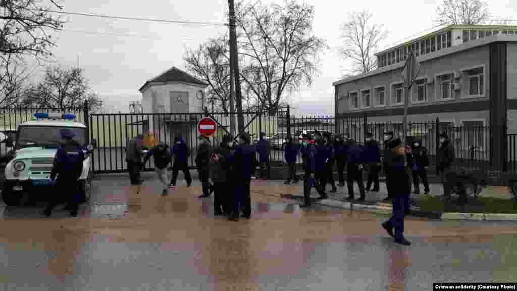 17 февраля в доме у крымского активиста Эдема Дудакова прошел обыск. Его обвинили в разжигании межнациональной розни за комментарий в соцсети, написанный в 2017 году. 18 февраля подконтрольный России Бахчисарайский районный суд присудил Дудакову 10 суток административного ареста. Во время заседания к зданию Бахчисарайского районного суда подъехал грузовик с сотрудниками Росгвардии. Сотрудники полиции зачитали собравшимся под судом предупреждение о недопустимости собраний, а затем начались задержания (на фото). По данным гражданского объединения «Крымская солидарность», российские силовики задержали 15 человек