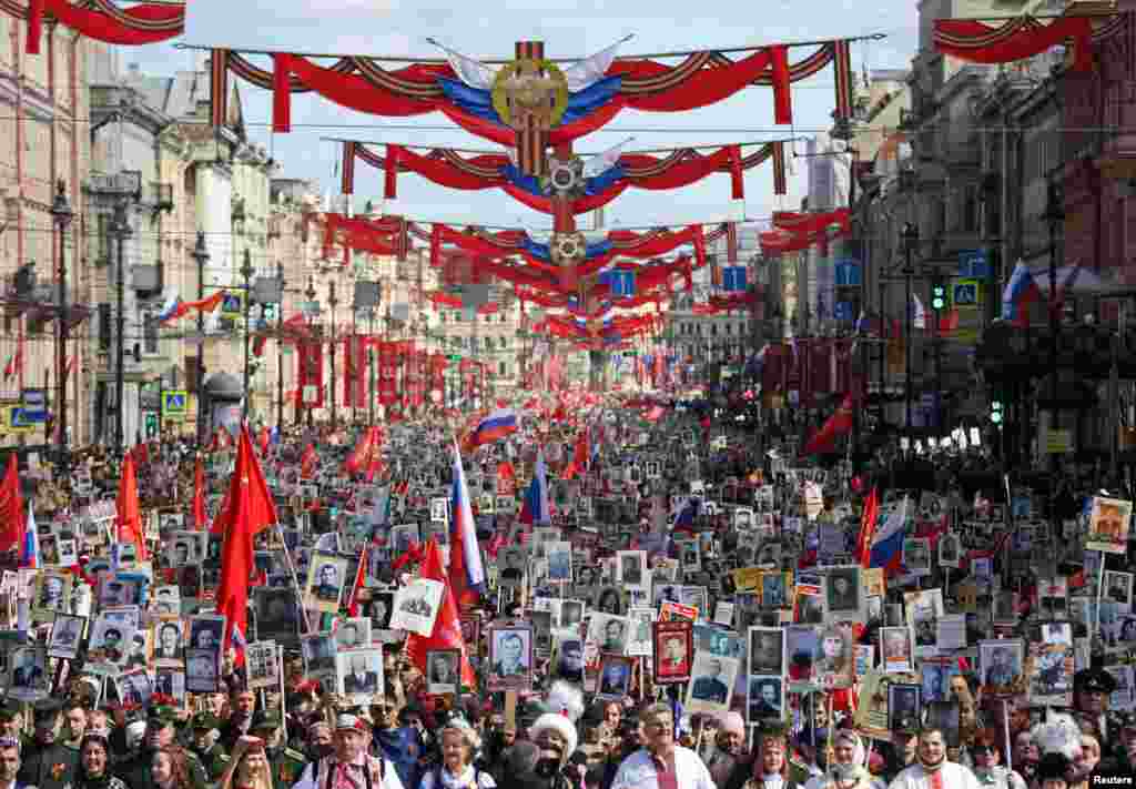 Люди несут портреты людей, в том числе солдат Красной Армии и ветеранов, во время шествия "Бессмертный полк" в День Победы в Санкт-Петербурге, Россия, 9 мая 2025 года. REUTERS/Anastasia Barashkova