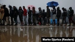 Migranti u redu za hranu u kampu Vučjak