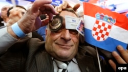 Pristalica HDZ-a sa stranačkom članskom kartom i vojnom značkom u Zagrebu slavi pobjedu na parlamentarnim izborima održanim 8. studenog 2015. godine, ilustrativna fotografija