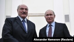 Russian President Vladimir Putin (right) poses for photographers with his Belarusian counterpart Alyaksandr Lukashenka during a meeting at the Kremlin in Moscow on December 25.