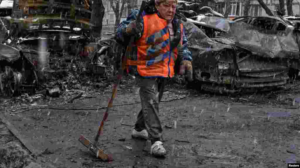 Ukrajinska komunalna radnica čisti područje na mjestu ruskog napada dronom na Dnjepar 9. aprila.