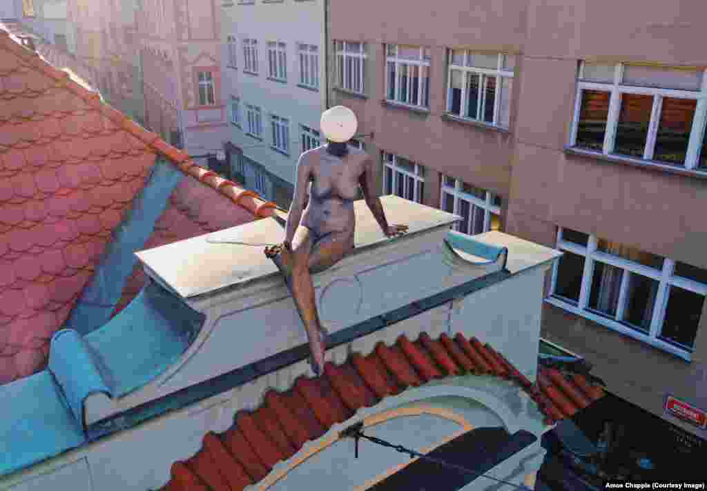 Статуя з ліхтарем замість голови на даху Деймового палацу в Старому місті