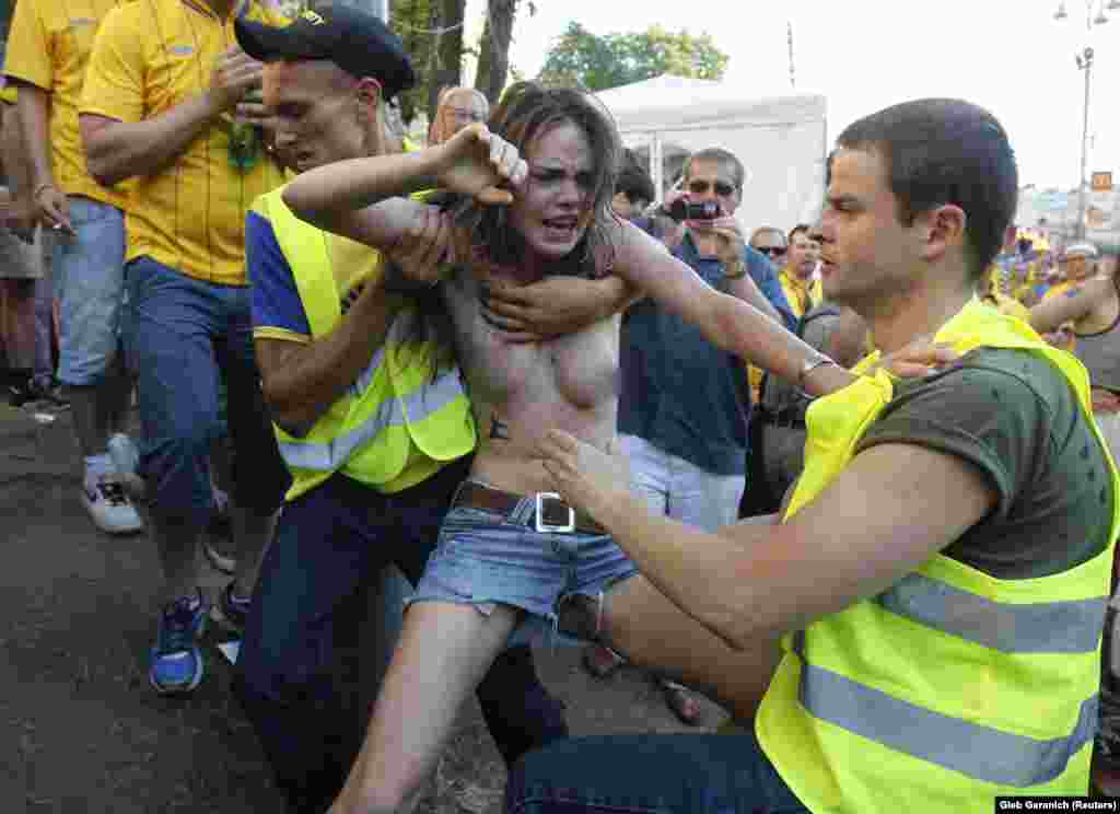 Сотрудник службы безопасности хватает Шачко во время протеста на чемпионате Европы в 2012 году. 