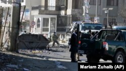 Afghan firefighters clean up the debris after a car bomb explosion in Kabul on December 31.