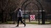 Stanovnik Prištine prolazi pored znaka zabrane ulaska u park u Prištini, 22. mart 2020. godine
