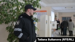 Un polițist la o secție de votare din Chișinău.