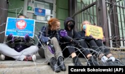 აქტივისტები მავთულხლართების უკან 23 აგვისტოს. მათ გამოხატეს პროტესტი პოლონეთის სასაზღვრო დაცვის შტაბ-ბინასთან ხელისუფლების პოზიციის მიმართ.