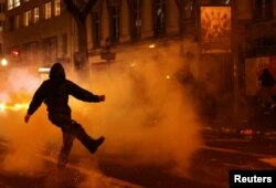 Maskirani prosvjednik šutira predmet usred sukoba s interventnom policijom tokom prosvjeda u sklopu devetog dana štrajkova i prosvjeda diljem zemlje protiv penzione reforme francuske vlade, u Parizu, Francuska, 23. marta 2023.