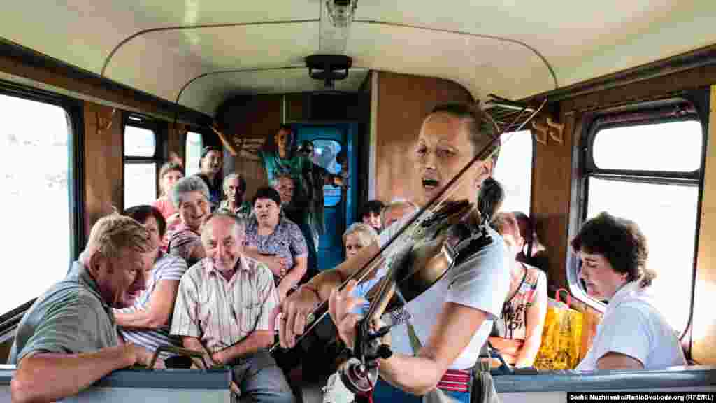 Музики у вагоні розважають пасажирів... і «Червона рута» (пісня Володимира Івасюка «Червона рута») стрімко линить над вагонами