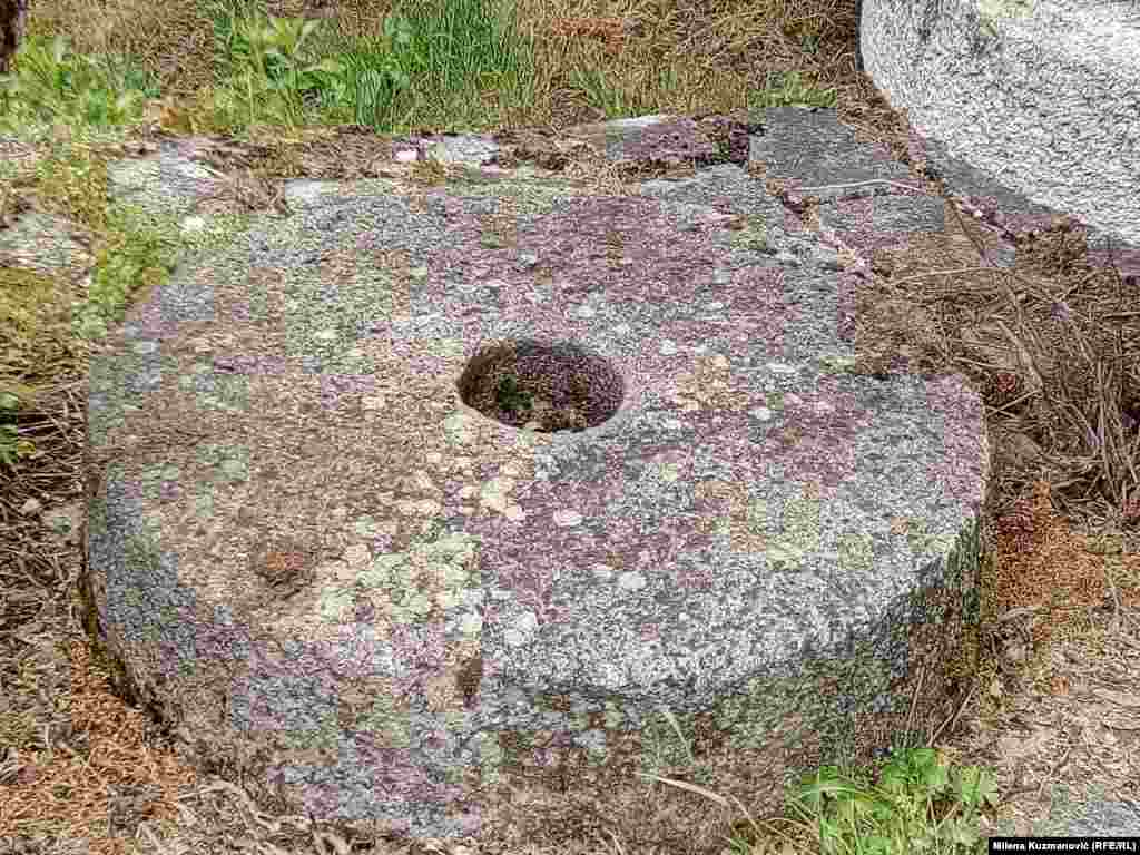 Vodenički točak koji je nekada mleo žito sada je bačen pored vodenice u travu. 