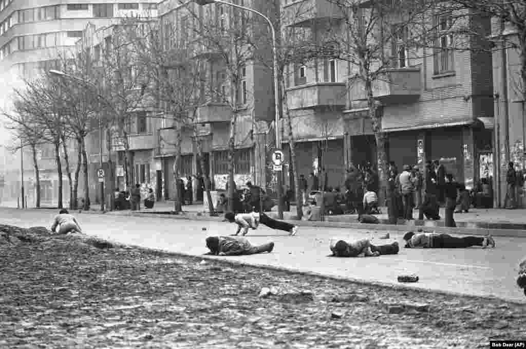 Ozbiljni nemiri razbuktali su se 26. januara, 1979. usred političke nestabilnosti i vakuma u vođstvu Irana. U Teheranu, antivladini demonstranti saginju se kako bi izbjegli metke koje ispaljuju vojnici.