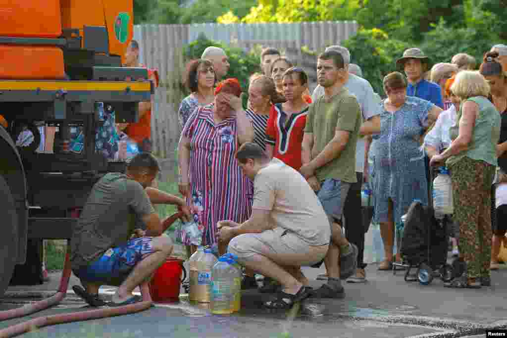 Ukrajinci čekaju u redu za vodu iz cisterne u Donjecku, koji je pod ruskom okupacijom.