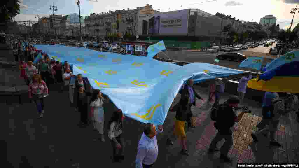 Люди йдуть Хрещатиком з національним прапором кримських татар під час мітингу з нагоди Дня кримськотатарського прапора, Київ, 26 червня 2018 року 