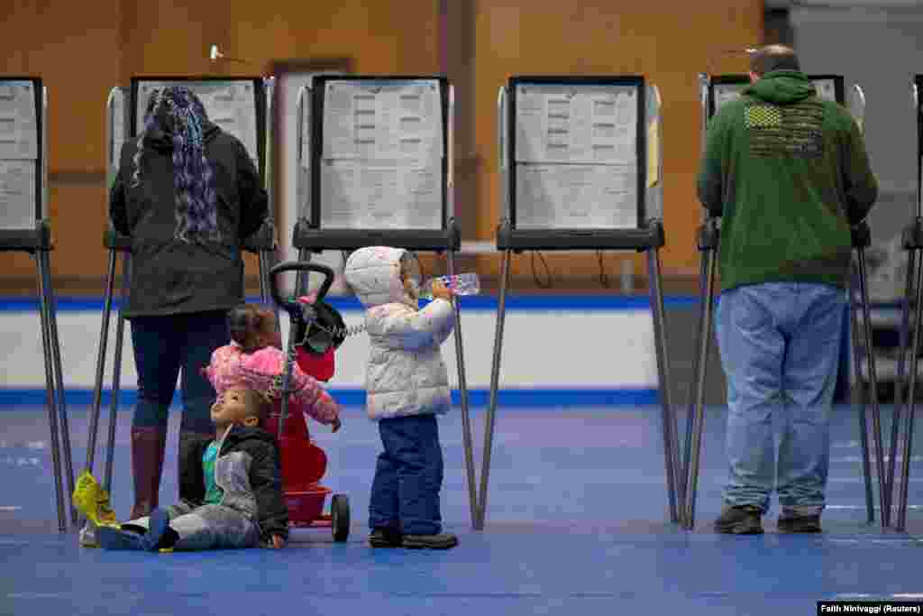 Rezultati izbora možda neće biti poznati i nekoliko dana. Daria Jones glasa dok je djeca čekaju, Lewinston, Maine