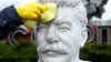 A volunteer cleans a bust of Soviet leader Josef Stalin during a community work day in the Muzeon Park of Arts in Moscow on April 13.