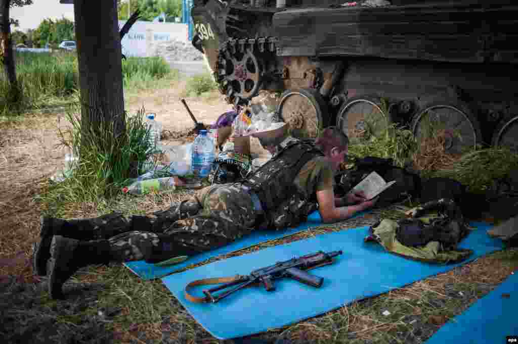 Український вояк читає довідкову військову літературу біля КПП на в’їзді до Маріуполя, 19 травня 2014 року