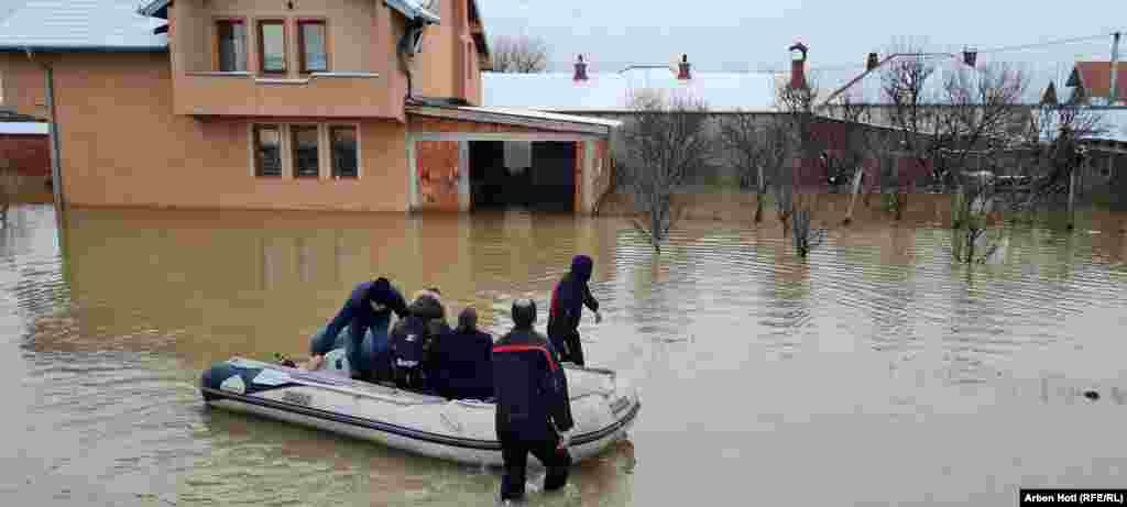 Zjarrfikësit evakuojnë me një barkë gome një familje në Vragoli të Fushë Kosovës. 