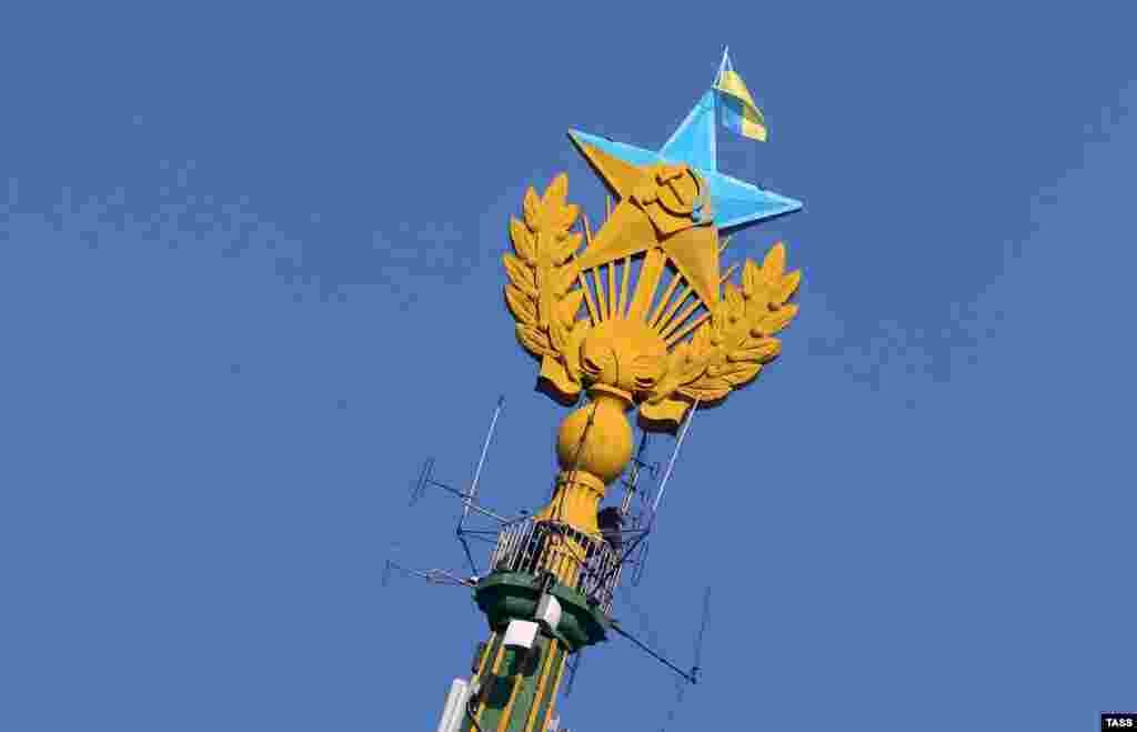 Радянська зірка перемальована в українські кольори та український прапор на будівлі сталінської висотки розташованої на Котельницькій набережній, Москва, 20 серпня 2014 року