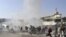 People react seconds after a suicide blast targeting a Shi'ite Muslim gathering in Kabul on December 6. Fifty-five people were killed and over 160 injured.