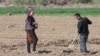 Uzbek farmers work in the field in spring in Karakalpakstan, Uzbekistan, Central Asia - April 2019