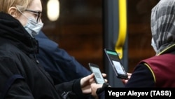 Кондуктор во время проверки QR-кодов у пассажиров в автобусе