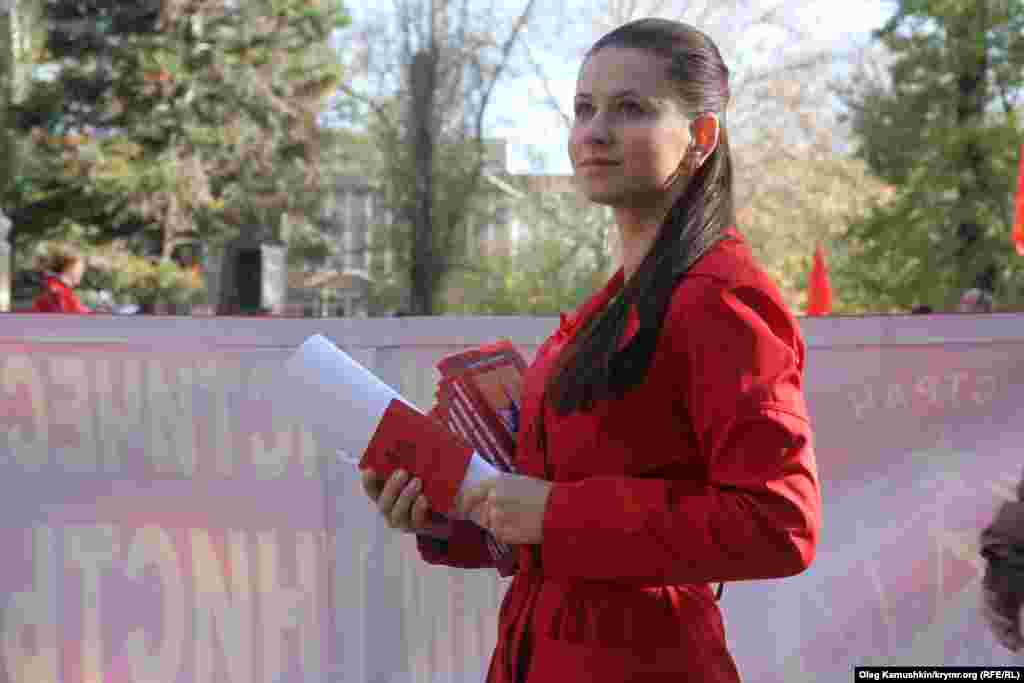 Девушка раздает партийные билеты новым участникам партии «Коммунисты России» 