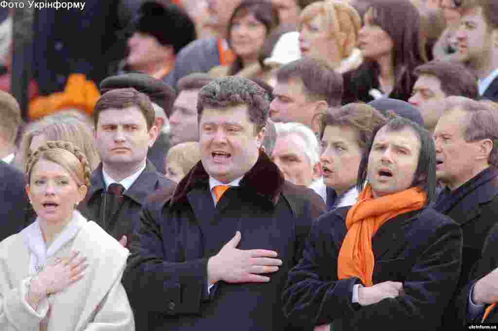 Слева направо: Юлия Тимошенко, Петр Порошенко и лидер группы "Океан Эльзы" Святослав Вакарчук во время неофициальной "общественной инаугурации" Виктора Ющенко на площади Независимости в Киеве. 23 января 2005 года