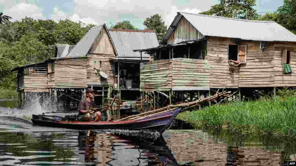 Na fotografiji: lokalni stanovnik kako čamcem kreće u ribolov u Lebungu."Slaba i neučinkovita kontrola i provođenje zakona omogućavaju nastavak eksploatacije tresetišta", rekao je za AFP Wahyu Perdana, predstavnik nevladine organizacije Pantau Gambut koja se bavi zaštitom tresetišta, osvrćući se na sve veći broj plantaža koje zauzimaju prostor tresetišta. AFP je kontaktirao i indonežansko ministarstvo za zaštitu okoliša, ali nisu odgovorili na postavljena pitanja.