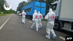 Ova fotografija, koju je snimio Koordinacioni štab za tretman ratnih zarobljenika 11. juna 2025., navodno prikazuje predstavnike Međunarodnog Crvenog križa kako prolaze pored kolone hladnjača koji prevozi tijela ukrajinskih vojnika.