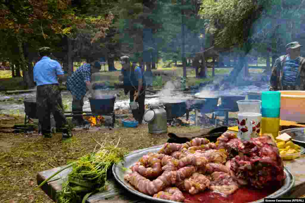 На берегу горной речушки всем селом готовят праздничное застолье. У казанов – только мужчины. Как поясняют местные, женщины подготавливают, а мужчины готовят. В меню много национальных блюд, обязательно с бараниной. В их числе дергем  - желудок барана, разрезанный лентой и сплетенный с полоской жира