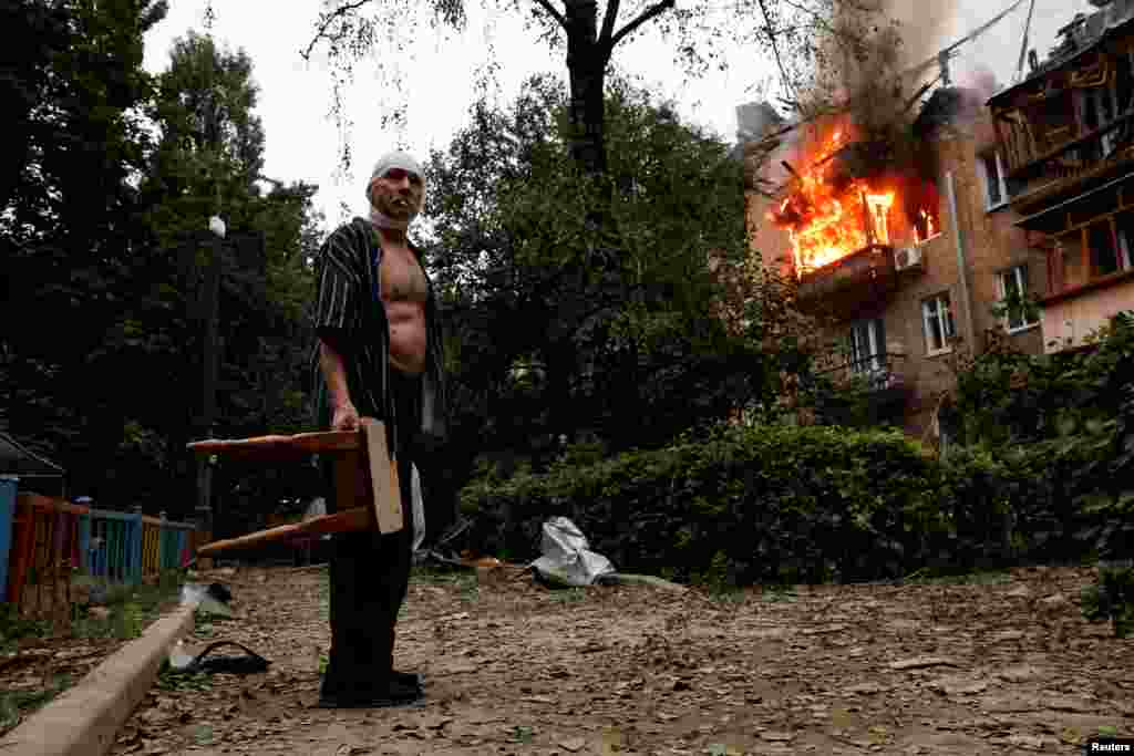 Povrijeđeni stanovnik ispred svoje kuće, koja je oštećena tokom ruskih raketnih napada i napada dronovima na Kijev.
