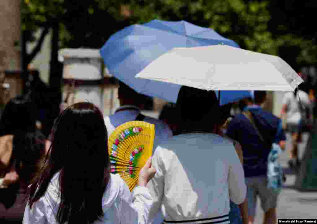 Një grua duke përdorur një flladitëse dore në Sevillë, më 29 qershor.