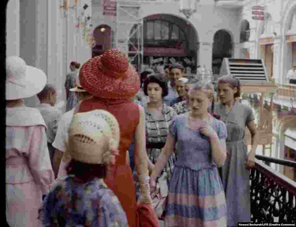 Советская женщина разглядывает платье. Минимально приличное платье в то время стоило зарплаты за полмесяца. А одежду от Диора даже представить себе было невозможно. 