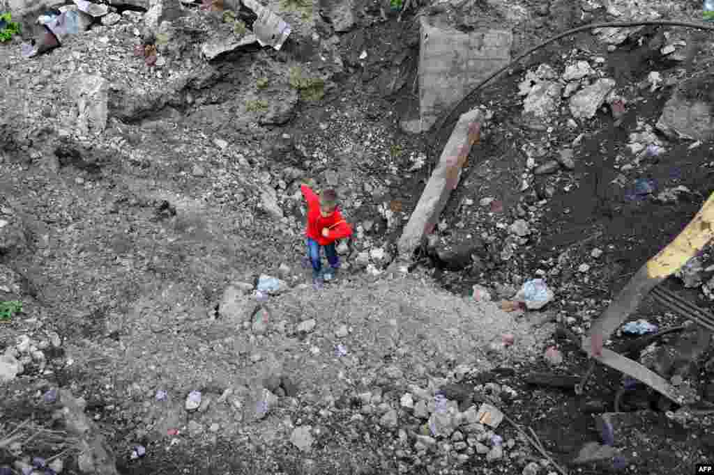 Хлопчик грається у воронці біля електромеханічного заводу Карла Маркса в Первомайську, 50 км на захід від Луганська, 28 вересня 2014 року