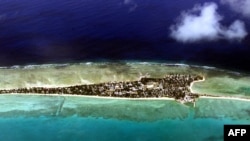 Atolul Tarawa, capitala statului Kiribati, într-o imagine aeriană din 2001. Altitudinea maximă: 2 m.