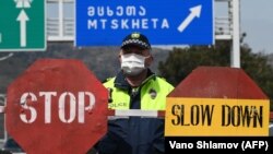 Gruzijski policajac nosi zaštitnu masku na kontrolnom punktu u Tbilisiju, 1. april, 2020.