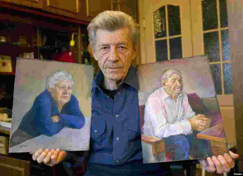 72-летний Владимир Романовский с портретами своих родителей - Ивана и Валентины. Они были арестованы соответственно в 1937 и 1938 годах. Оба провели много лет в лагерях на Крайнем Севере.