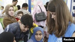 A UN worker takes down the names of Iraqi families at a refugee center in Damascus.