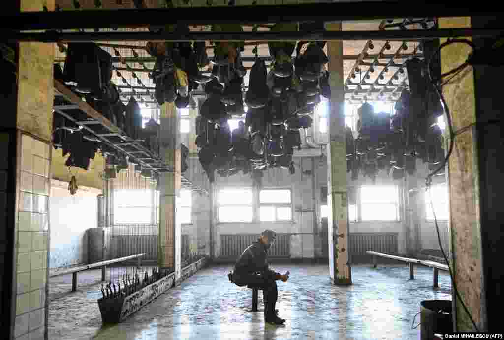 Radna odjeća visi na stropu svlačionice.