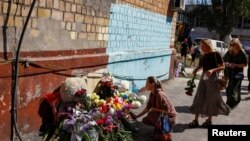 Žene polažu cveće na mestu gde je dan ranije Rusija izvela veliki napad na stambenu zgradu u Kijevu, 29. avgsuta 2025.