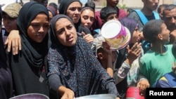 Palestinci čekaju da dobiju hranu iz humanitarne kuhinje, Nusejrat, Pojas Gaze, 20. jul 2025.