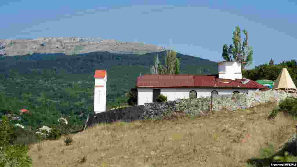 Церква преподобного Афанасія Печерського височіє над Романівським шосе, яке веде до монастиря Косьми та Даміана на території Кримського природного заповідника. На дальньому плані – південний край Чатир-Дага, Красний Рай, с.Ізобільне