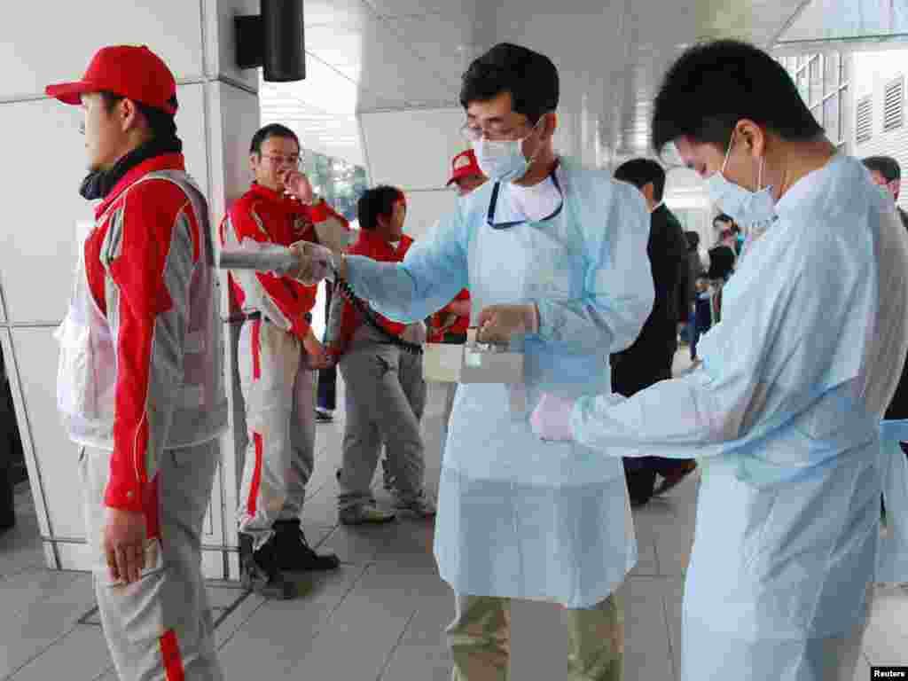 Djelatnici Crvenog križa mjere nivo radijacije u Nagahamau, 14.03.2011. Foto: Reuters / Kyodo